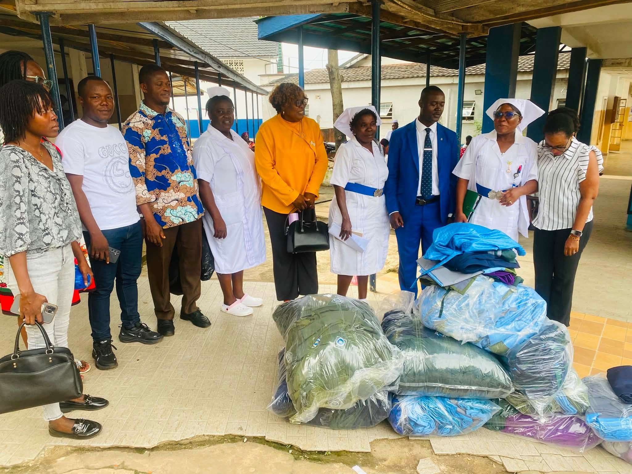 Packed bags of theatre linen at a hospital, with health workers and programme staff standing beside them